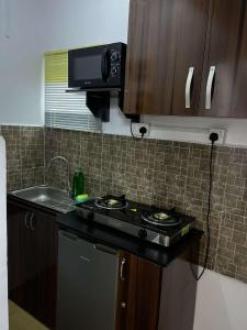 Il comprend une petite cuisine équipée d'une cuisinière et d'un évier. dans l'établissement GS HOMES, à Lagos