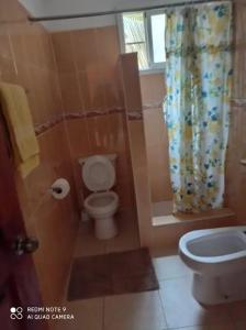 a bathroom with a toilet and a shower curtain at Sunny Apartment in Bayahibe