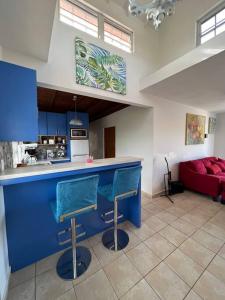 a kitchen with a blue counter and a red couch at Playa y Campo Getaway Apartment, with Hot Tub in Isabela