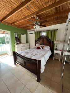 a bedroom with a large bed with a wooden headboard at Playa y Campo Getaway Apartment, with Hot Tub in Isabela