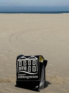 una bolsa sentada en la arena en una playa en B&B bINNengewoon rooms with a view en Veere