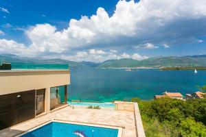 uma casa com piscina e vista para a água em Villa Semiramis em Tivat