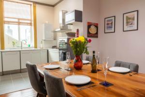 a dining room table with chairs and a vase of flowers at Beautiful Grade II listed apartment. in Leek