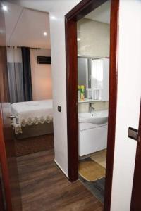 uma casa de banho com um espelho, um lavatório e uma cama em Haut-Standing- Appartement-Fes-City em Fez