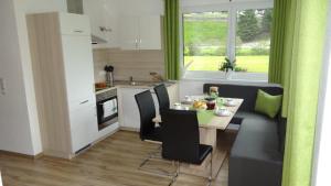 eine Küche und ein Esszimmer mit einem Tisch und Stühlen in der Unterkunft Apart Alpenflair in Sankt Leonhard im Pitztal