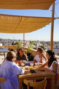 Un groupe de femmes assises à une table sur un toit dans l'établissement Battuta Hostel, à Amman