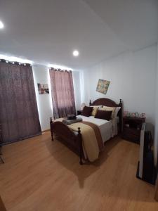a bedroom with a large bed and wooden floors at Studios Rossio in Viseu
