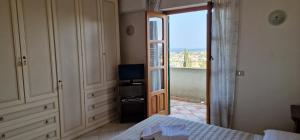 een slaapkamer met een bed en een deur naar een balkon bij Villa Anna in Marsala