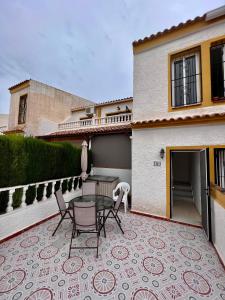 une terrasse avec une table et des chaises devant une maison dans l'établissement Calle canarias, à Gran Alacant