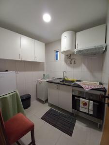 a small kitchen with white cabinets and a sink at Studios Rossio in Viseu