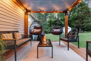 d'une terrasse avec 2 balançoires et une table. dans l'établissement Sidney Springs Cottage, 