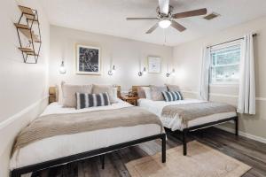 2 camas en una habitación con ventilador de techo en Sidney Springs Cottage, 