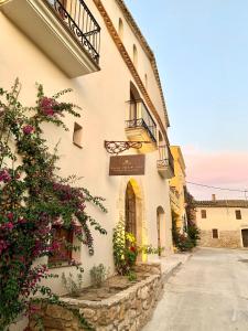 un edificio con flores a un lado. en Casa Gran 1771 - MontRubí Winery Hotel - Adults Only en Font-Rubí