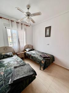 a bedroom with two beds and a ceiling fan at Calle canarias in Gran Alacant +13 photos