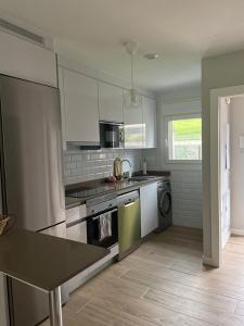 a kitchen with a sink and a stove top oven at Casa adosada agradable entre playas y montañas in Caravia