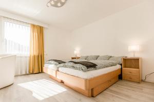 a white bedroom with a bed and a window at Ferienwohnung Ägerisee in Oberägeri