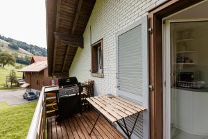 a porch with a grill and a bench on a deck at Ferienwohnung Ägerisee in Oberägeri
