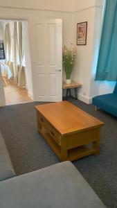 a living room with a coffee table in front of a door at Bexhill Luxury Sea Stay Flat 2 in Bexhill