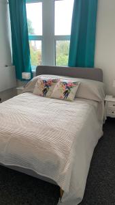 a bedroom with a bed with two pillows on it at Bexhill Luxury Sea Stay Flat 2 in Bexhill
