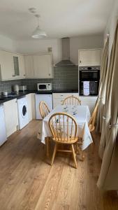 a kitchen with a table and chairs in a kitchen at Bexhill Luxury Sea Stay Flat 2 in Bexhill