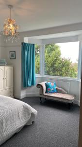 sypialnia z kanapą i dużym oknem w obiekcie Bexhill Luxury Sea Stay Flat 2 w mieście Bexhill