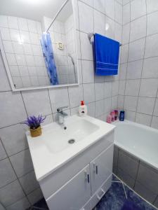 La salle de bains blanche est pourvue d'un lavabo et d'une baignoire. dans l'établissement Apartman Sky, à Bijeljina