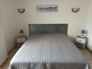 a bedroom with a large bed with two night stands at Le Jardin du Somail in Le Somail