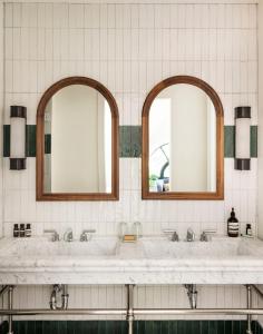 a bathroom with two sinks and two mirrors at The Quoin Hotel in Wilmington