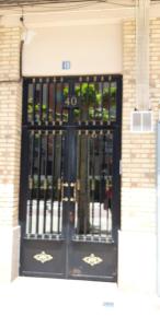 a black door with a metal gate on a building at Apartamentos El Conde in Santo Domingo de la Calzada