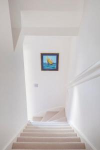a staircase in a building with a painting on the wall at Coastguard Cottage in Milford on Sea