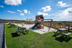 a playground with picnic tables and a slide at Stewarts Resort Lodge 26 in St. Andrews