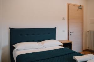 een bed met een blauw hoofdeinde in een slaapkamer bij Dal Patricano in Frosinone