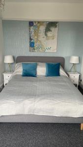 a bedroom with a large bed with blue pillows at Bexhill Luxury Sea Stay Flat 2 in Bexhill