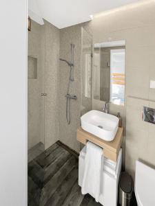 a bathroom with a sink and a shower at Sea Light Apartment Sesimbra. 2 bedrooms, 6 guests in Sesimbra