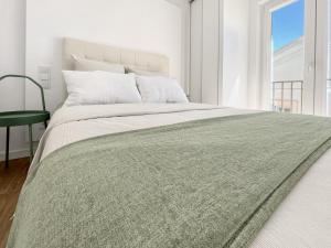 a bedroom with a large bed with a green blanket at Sea Light Apartment Sesimbra. 2 bedrooms, 6 guests in Sesimbra