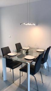uma mesa de jantar com cadeiras pretas e uma sala de jantar em Royal Beach 607 em Pilar de la Horadada
