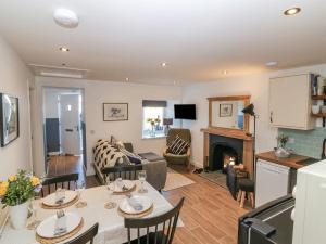 a kitchen and living room with a table and chairs at Lindsay Cottage in Kirriemuir