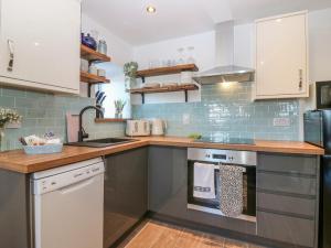 a kitchen with a sink and a stove top oven at Lindsay Cottage in Kirriemuir