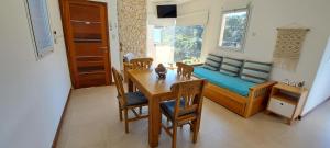 a dining room with a table and chairs and a couch at Arena de Mar Depto L in Mar de las Pampas