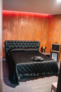 1 dormitorio con cama negra y pared roja en Dal Patricano, en Frosinone