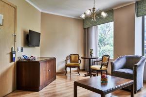 ein Wohnzimmer mit einem Tisch und Stühlen in der Unterkunft Hotel Poblado Plaza in Medellín