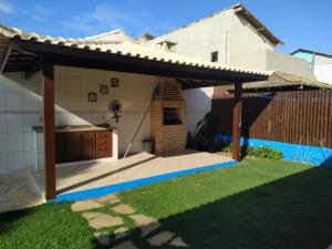 a house with a patio with a brick fireplace at Casa Azul em Búzios in Búzios