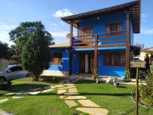 une maison bleue avec un panneau devant elle dans l'établissement Casa Azul em Búzios, à Búzios