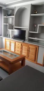 un soggiorno con tavolo e TV a schermo piatto di Apartamento Alba a Portonovo