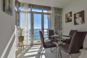 a dining room with a table and chairs and a large window at Estudio Loft Horizonte Playa Fossa Calpe in Calpe