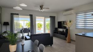 een woonkamer met een bank en een televisie bij Beautiful luxury villa with private pool in Palm-Eagle Beach