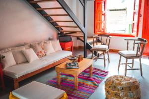 een woonkamer met een bank en een tafel en stoelen bij Casa Hotel El Porton SALENTO in Salento
