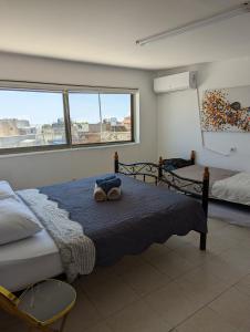 a bedroom with two beds and two windows at New Citadel Hostel in Jerusalem