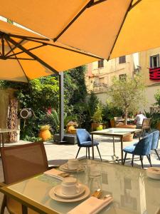 a table with chairs and an umbrella on a patio at Hotel POZZO DI BORGO in Ajaccio