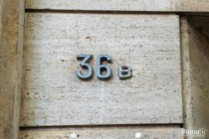 un número de casa al lado de un edificio en Romatic, en Roma
